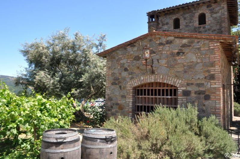 Castello Di Amorosa: каменная башня с решётчатым окном и винными бочками